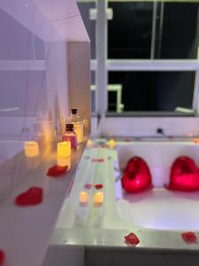 a table with red hearts and candles on it at Casa com banheira in Governador Celso Ramos