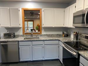 a kitchen with white cabinets and a sink at LINCOLN WHITE MOUNTAIN RETREAT - Loon Mnt, King bed, Monthly Rental in Lincoln