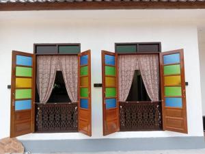 a room with two doors and windows in a house at Homestay Senggarang in Senggarang