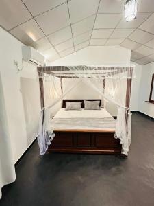 a bed with a canopy in a room at Walawe Palm Villa in Udawalawe