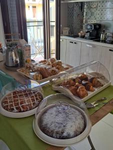 a table with several trays of different types of pastries at elegance b&b in Cariati
