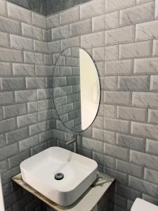 a bathroom with a white sink and a mirror at Central Hideaway in Thong Sala
