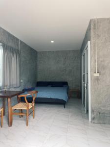 a bedroom with a bed and a table and chairs at Central Hideaway in Thong Sala