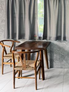 a wooden table and two chairs next to a window at Central Hideaway in Thong Sala