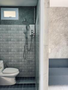 a bathroom with a shower with a toilet and a staircase at Central Hideaway in Thong Sala