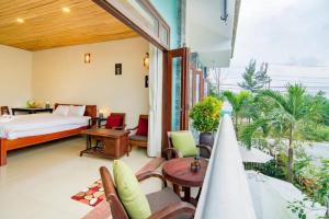 a bedroom with a bed and a table and chairs at Homestay Ocbien in Hoi An