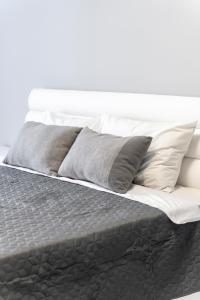 een bed met grijze en witte kussens erop bij RentWill apartments Silver in Chişinău