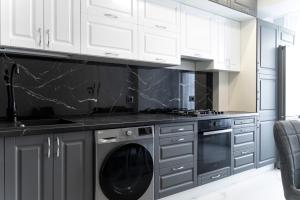 een keuken met witte kasten en een zwarte vaatwasser bij RentWill apartments Silver in Chişinău +12 foto's