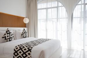 チャングーにあるChic Designer 1 BR villa with poolのベッドと大きな窓のある寝室 +8枚の写真