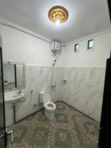 a bathroom with a toilet and a sink at Hotel Any Lestari in Huu