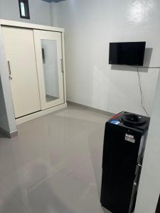 a room with a mirror and a trash can at Hotel Any Lestari in Huu +1 photo