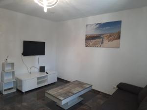 a living room with a couch and a tv on a wall at Wohnen wie Zuhause in Abstatt
