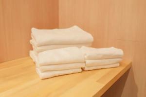 three stacks of white towels sitting on a shelf at Kawaguchi Asama Jinjakan - Diamond Yu in Azagawa +34 photos