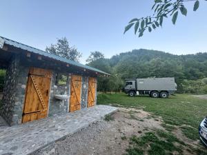 a truck is parked next to a house with a toilet at Camp TARA in Mojkovac