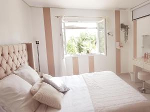 a bedroom with a white bed with a window at Ginatella - 3 chambres in Deaux +28 photos
