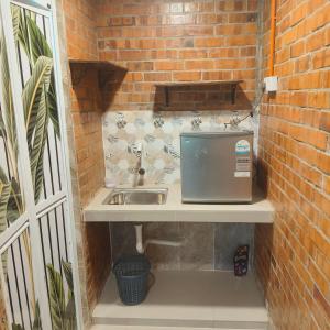 a bathroom with a sink and a brick wall at Bang Brahim Roomstay in Parit Raja