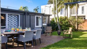 a table and chairs in a backyard with a caravan at Beach Bungalow in Corlette