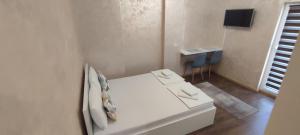 a white bed in a room with a table at Menrat in Novi Sad