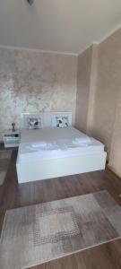 a large white bed in a room with wooden floors at Menrat in Novi Sad