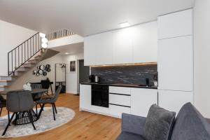 a kitchen and living room with a table and chairs at Luxury Apartment - PERLIUKAS in Palanga