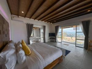a bedroom with a large bed and a large window at Elephantpoolvilla maetang Chiangmai in Ban Muang Kut +21 photos