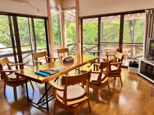 a dining room with a table and chairs and windows at フルブルーム in Nasu-yumoto