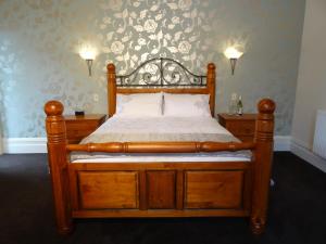 um quarto com uma cama de madeira com uma estrutura de madeira em Villa Shakespeare em Cambridge
