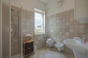 a bathroom with a sink and a toilet and a window at Casa al Cor Apartments in Nago-Torbole