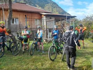 un gruppo di persone che se ne stanno in piedi con le biciclette davanti a una cabina di Guest House in Svaneti - Khaishi a Mestia