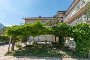 a building with an arch in front of a yard at Casa al Cor Apartments in Nago-Torbole