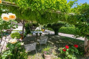 a garden with chairs and flowers and plants at Casa al Cor Apartments in Nago-Torbole +97 photos