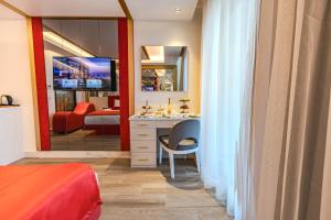 a bedroom with a bed and a desk and a mirror at Granada Luxury Red Adult Only in Alanya