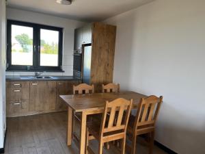 PrabutyにあるSielskie Wakacjeのキッチン(木製ダイニングテーブル、椅子付)
