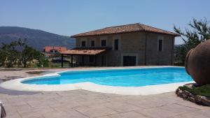 a swimming pool in front of a house at Finca la Carb0nera in Oliva de Plasencia