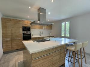 a kitchen with wooden cabinets and a large counter top at La maison de julie in Burosse-Mendousse