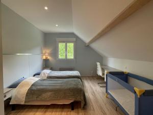 a attic bedroom with a bed and a window at La maison de julie in Burosse-Mendousse +23 photos