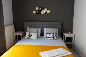 a bedroom with a bed with a yellow blanket and two tables at Evelina 5 in Lixouri