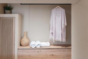 a room with a shelf with a robe and shoes at Helios - Luxury by the Sea in Paralia Katerinis