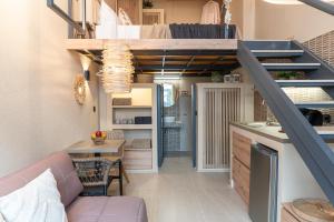 a living room with a couch and a staircase at Helios - Luxury by the Sea in Paralia Katerinis