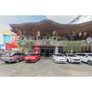 un parcheggio con auto parcheggiate davanti a un edificio di Urbanview Hotel Utari a Bandung