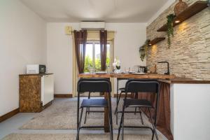 a kitchen with a counter and three bar stools at Schilirò House in Piedimonte Etneo
