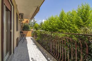 a balcony of a house with a fence and chairs at Schilirò House in Piedimonte Etneo