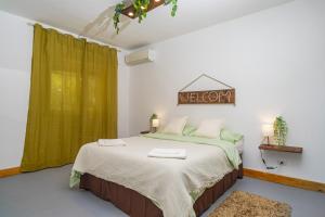 a bedroom with a bed with a green curtain at Schilirò House in Piedimonte Etneo