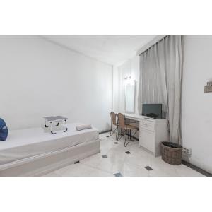 Camera con letto e scrivania con computer. di Urbanview Hotel Utari a Bandung