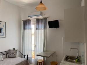 a bedroom with a bed and a window with a sink at ERRIKA in Ermoupoli