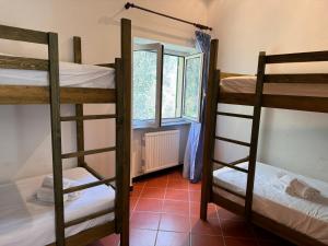 una habitación con tres literas y una ventana en Casa Rosa, en Bracco 3 fotos más