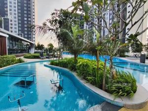 a swimming pool with blue water and trees and buildings at D'Splash Homestay SplashMania in Banting