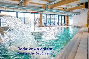 une piscine avec deux fontaines dans un bâtiment dans l'établissement Bel Mare Aqua, à Międzyzdroje