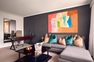 a living room with a couch and a piano at Sofitel Brisbane Central in Brisbane