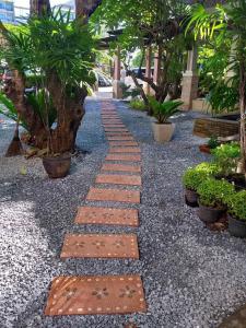 einen Gehweg in einem Garten mit Pflanzen und Bäumen in der Unterkunft Bangkok Resort and Spa in Ban O Pao